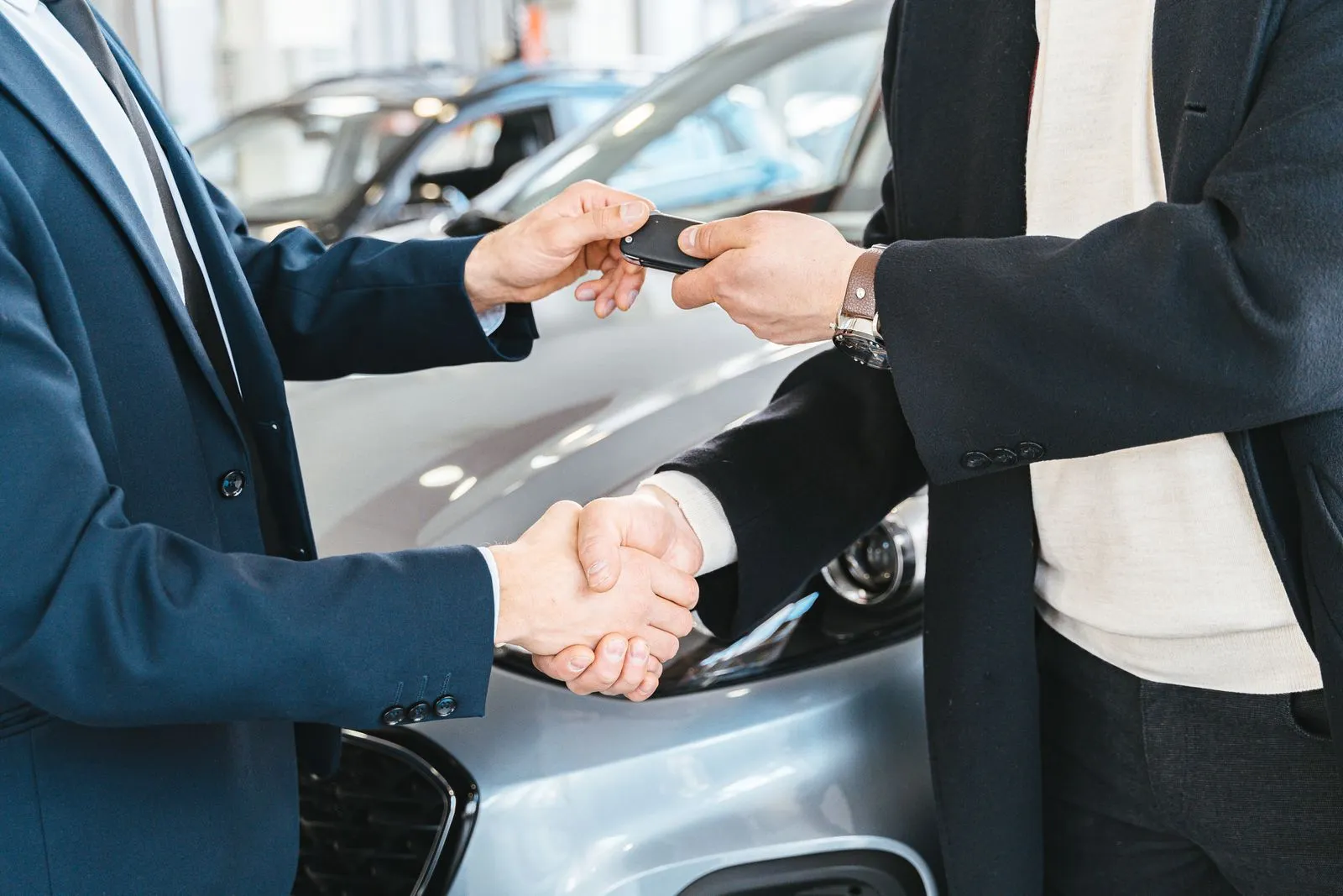 Vendedor entregando las llaves de un auto a un cliente
